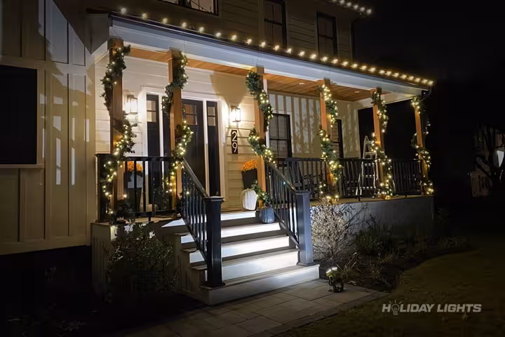 Elegant Christmas garlands decorating porch pillars with warm white LED lighting Elegant Christmas garlands decorating porch pillars with warm white LED lighting