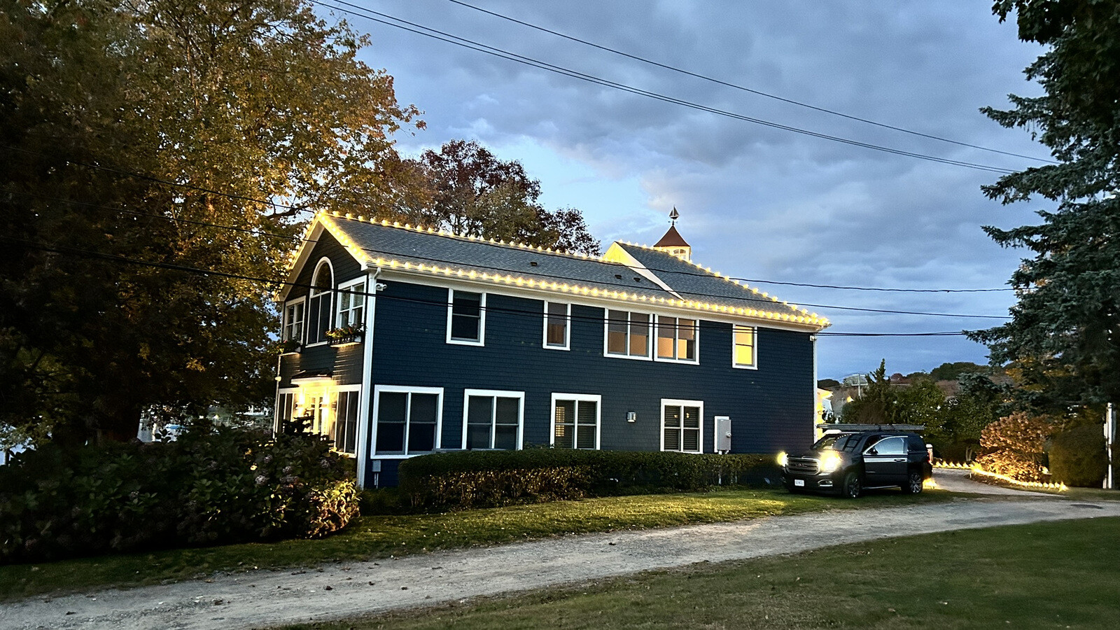 Permanent LED roofline lighting on an upscale home at dusk